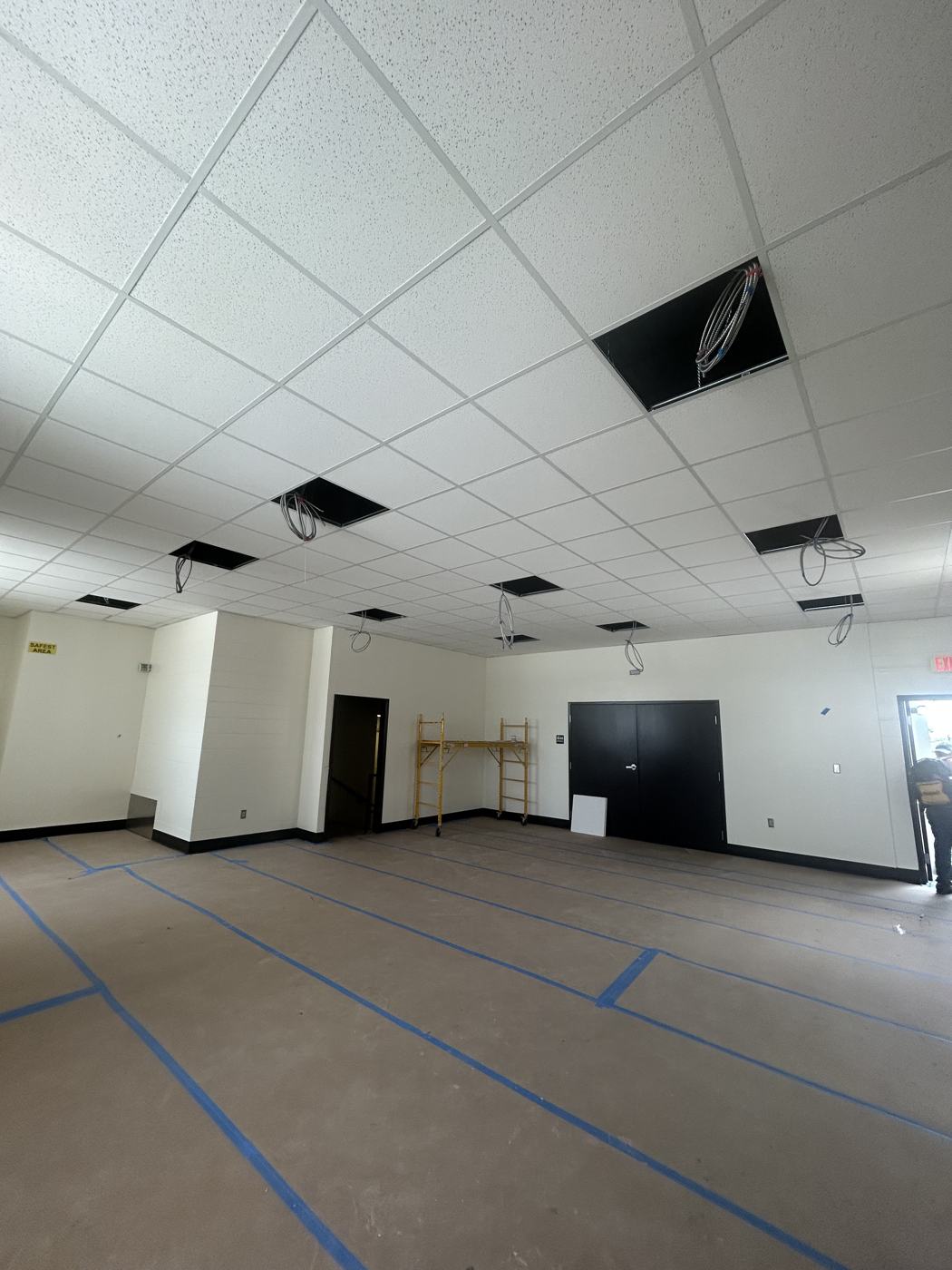 Ceiling tile installed, openings ready for new light fixtures.