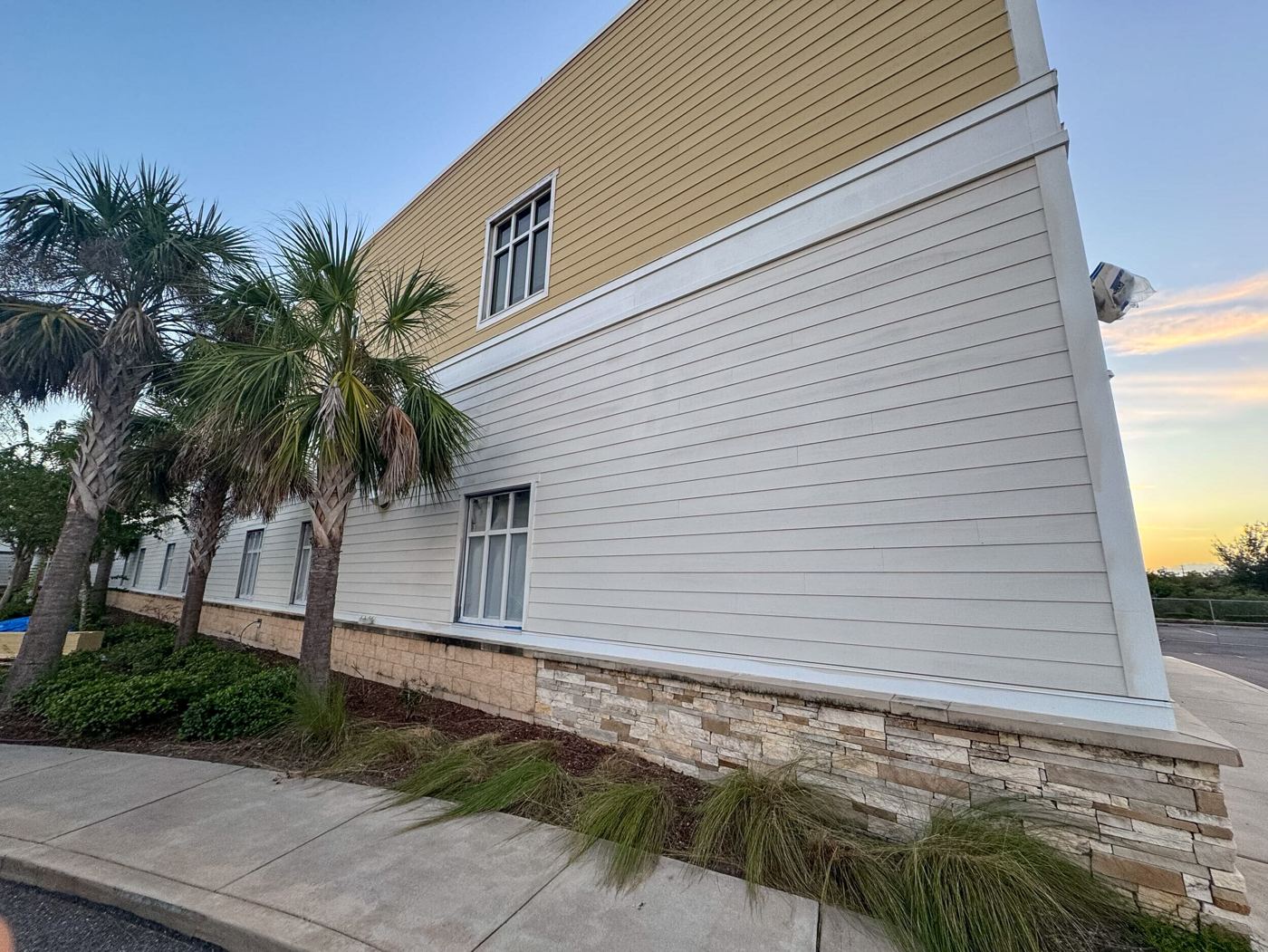 Close view of new white and tan Hardie siding and trim on the hospital exterior at sunset.